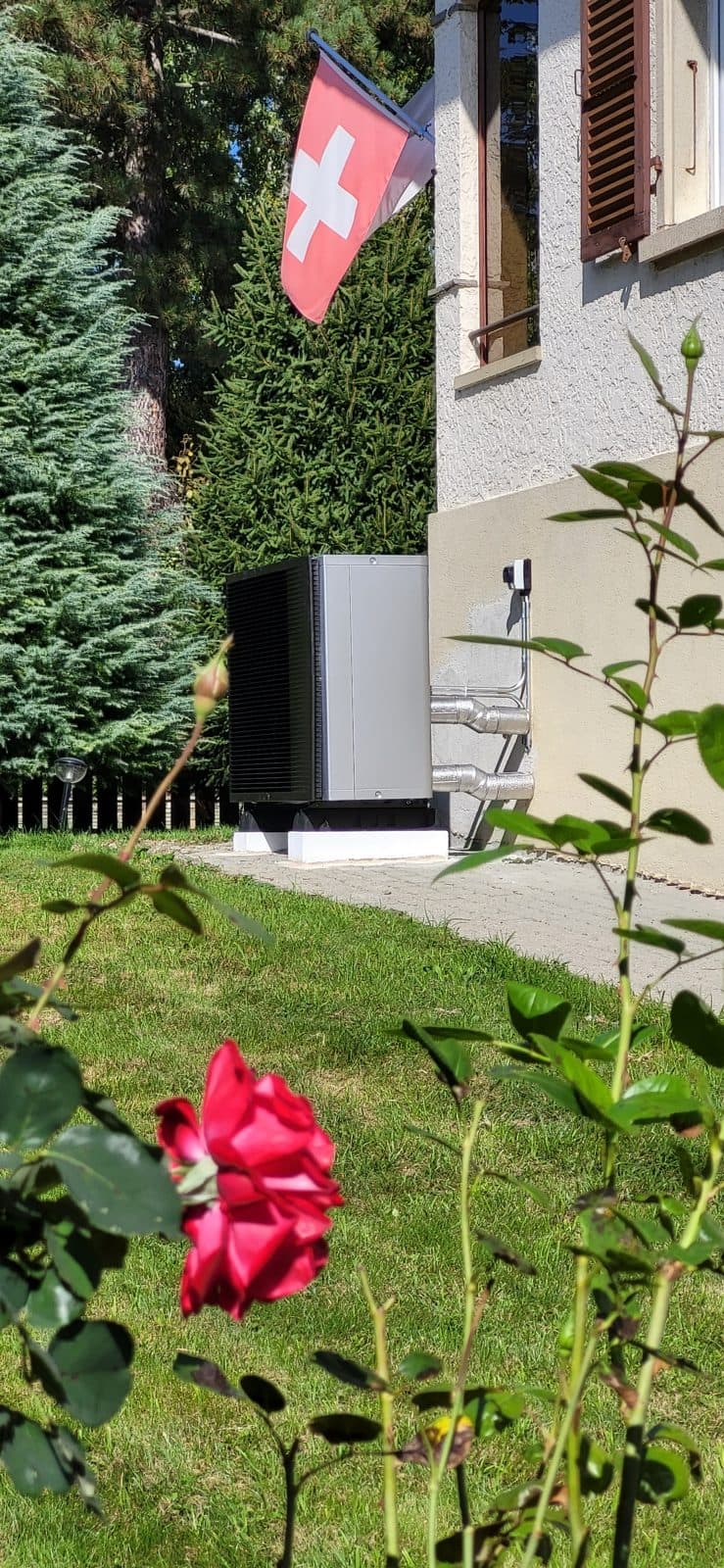 Pompe à chaleur air-eau installée dans le jardin d'une maison à Domdidier, canton de Fribourg